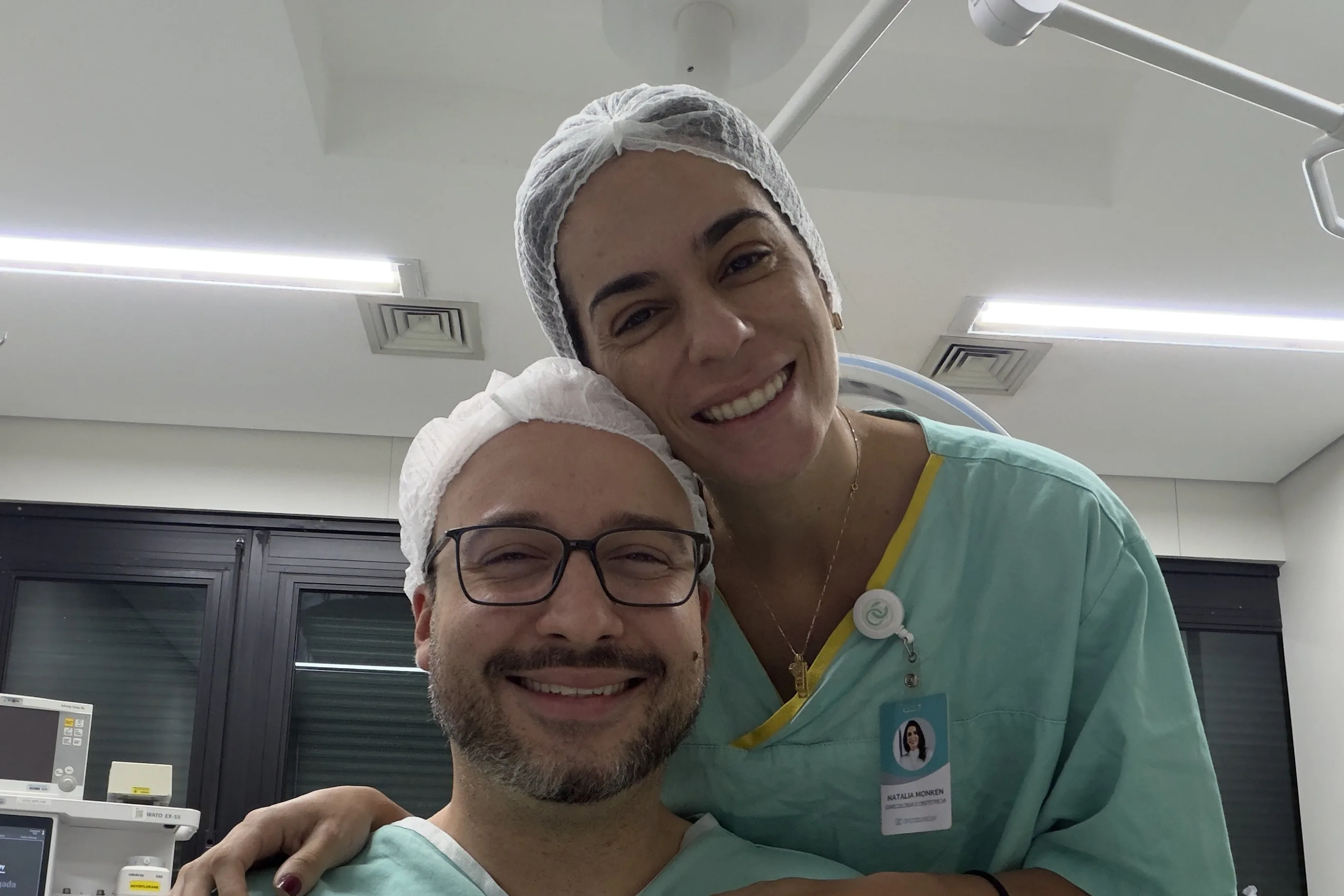 Dra. Natália e Dr. Frederico Monken, obstetras em Belo Horizonte, de touca e pijama cirúrgico no centro cirúrgico