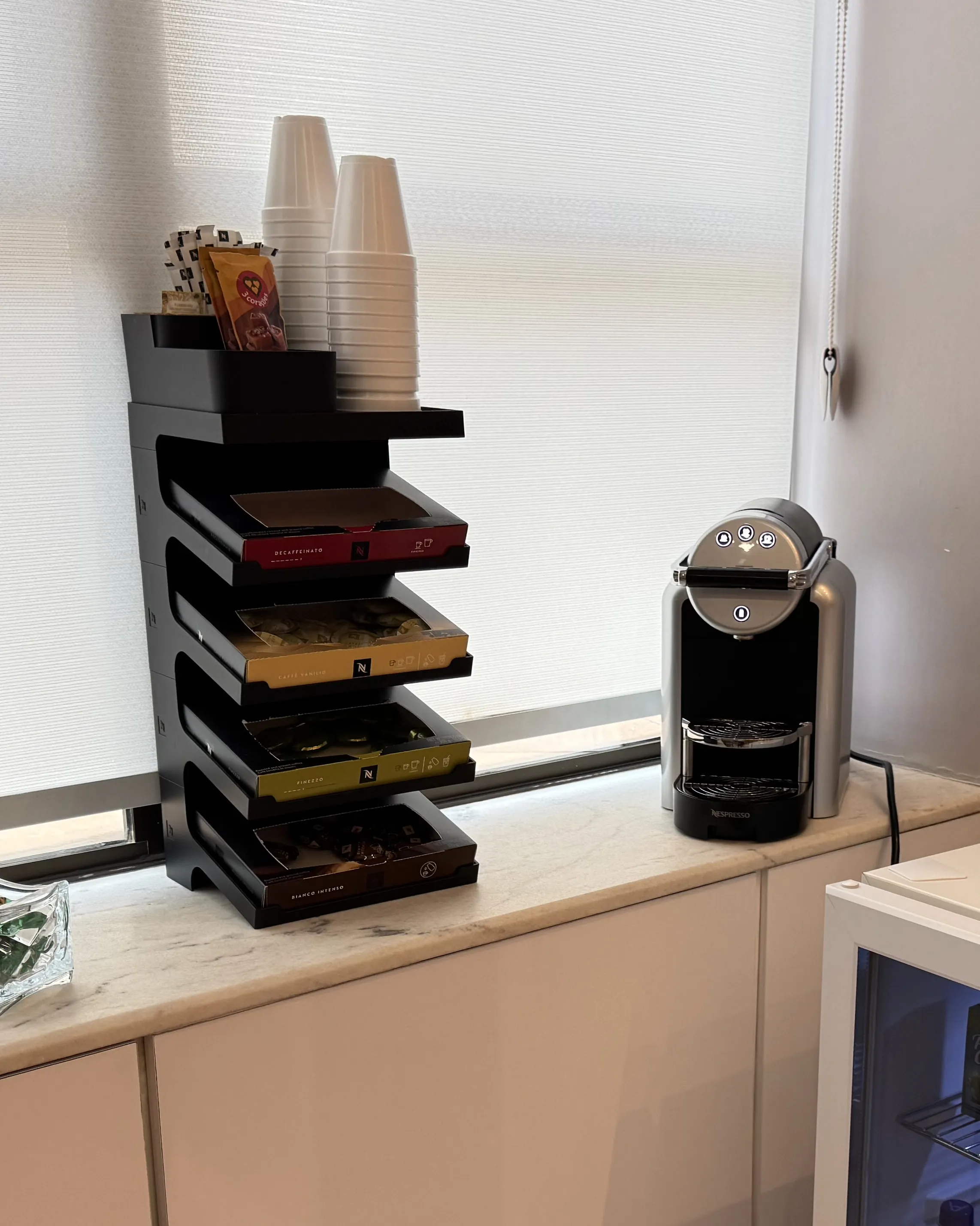 Cápsulas e máquina de café sobre o mármore
